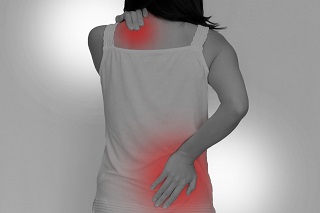 肩こりと腰痛を抱える女性の後ろ姿写真
